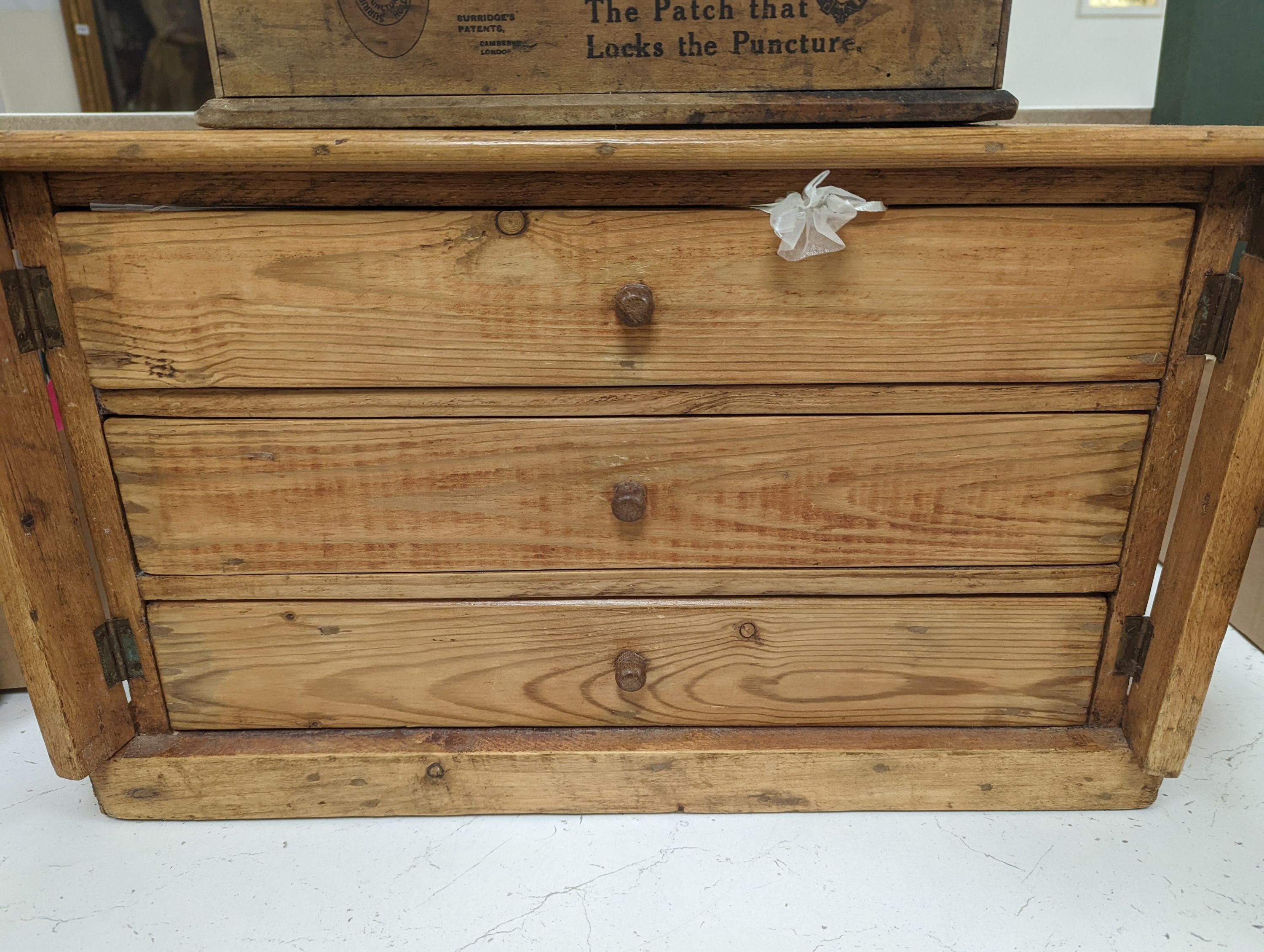 A 'Holdtite' shop cabinet and a pine three drawer chest, housing some costume jewellery